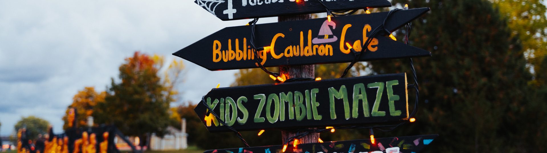 Some directional signage at pumpkinferno with pumpkin displays in the background