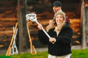 A guest throws a ball with a lacrosse stick