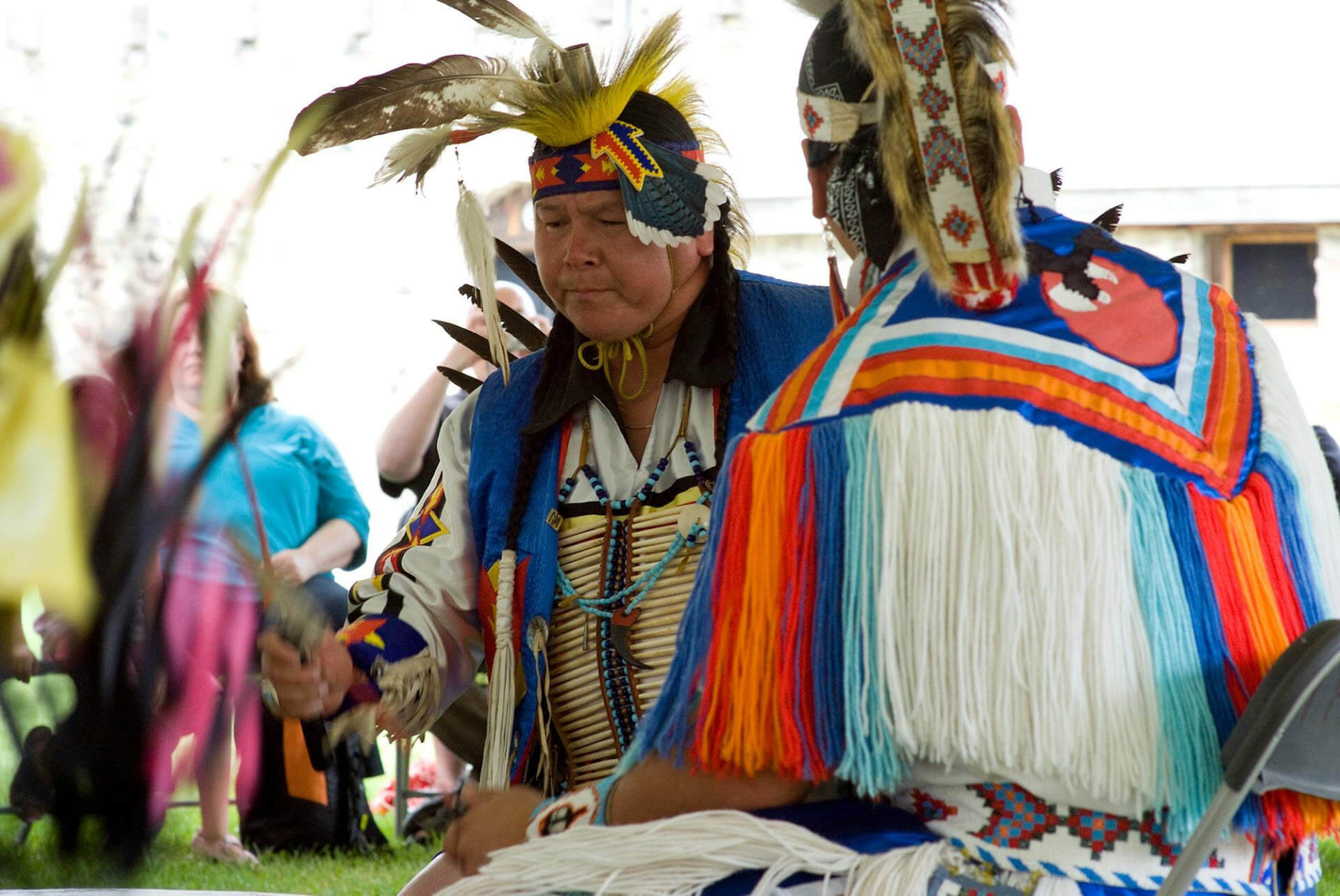 Deux hommes autochtones en habits cérémoniaux à jouer un gros tambour