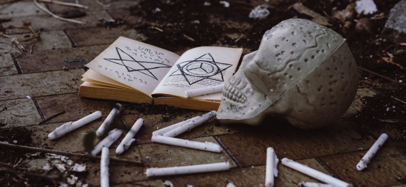 A book with a skull and cigarette sticks on the ground