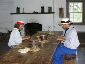 two sailors crafting at a table inside the Sailors’ Barracks