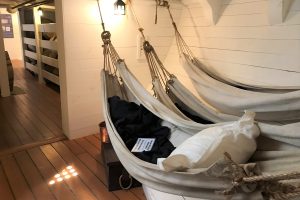 sailors hanging hammocks inside of HMS Tecumseth