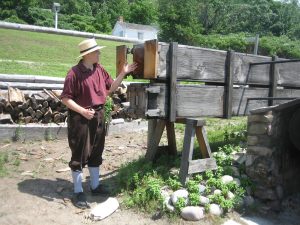 man pulling a wooden plank from Steam Kiln