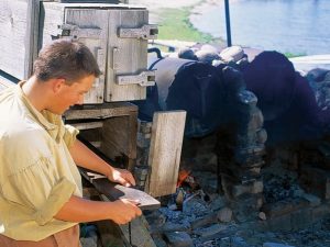 man curving a wooden plank from Steam Kiln